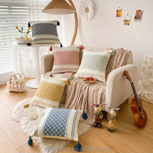 Collection of colourful Moroccan boho cushion covers arranged on a floor and sofa